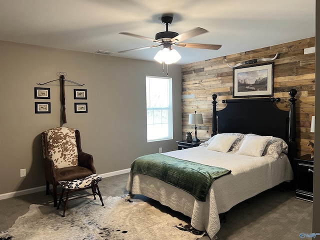 bedroom with dark carpet, visible vents, wood walls, and baseboards