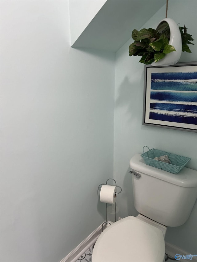 bathroom with toilet and baseboards