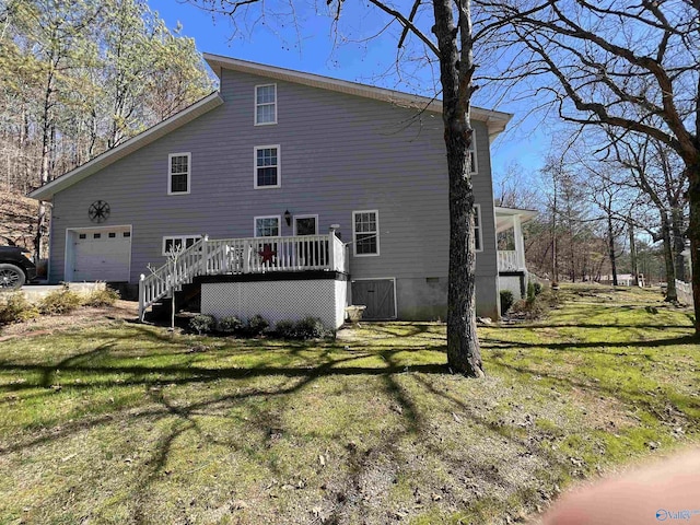 view of side of property with a garage, a lawn, and a wooden deck