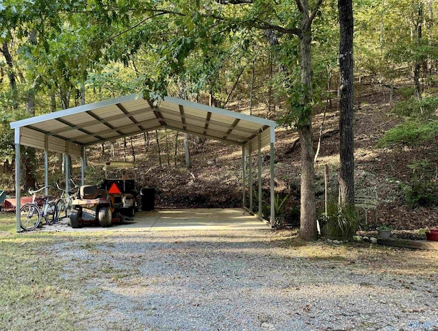 view of parking / parking lot featuring a carport and gravel driveway