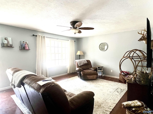 living room featuring a textured ceiling, dark hardwood / wood-style floors, and ceiling fan