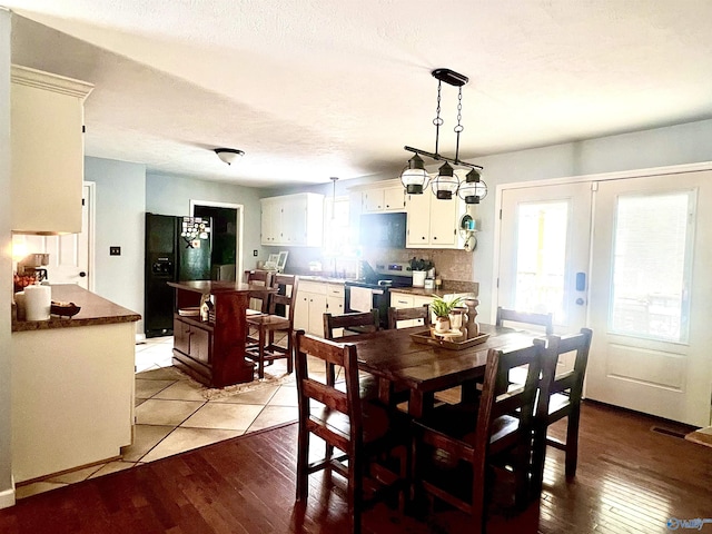 dining space featuring french doors, a textured ceiling, and light wood-type flooring