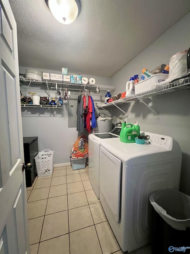 laundry room with independent washer and dryer, a textured ceiling, and light tile patterned flooring