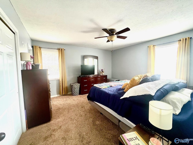 carpeted bedroom with multiple windows, ceiling fan, and a textured ceiling