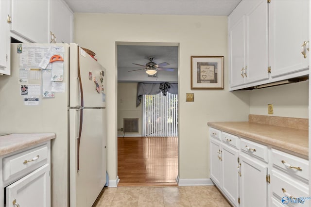 kitchen with white cabinets, white fridge, light hardwood / wood-style flooring, and ceiling fan