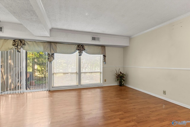 unfurnished room featuring ornamental molding, a textured ceiling, and hardwood / wood-style floors