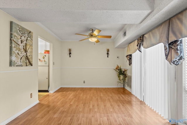 unfurnished room featuring crown molding, a textured ceiling, light wood-type flooring, and ceiling fan