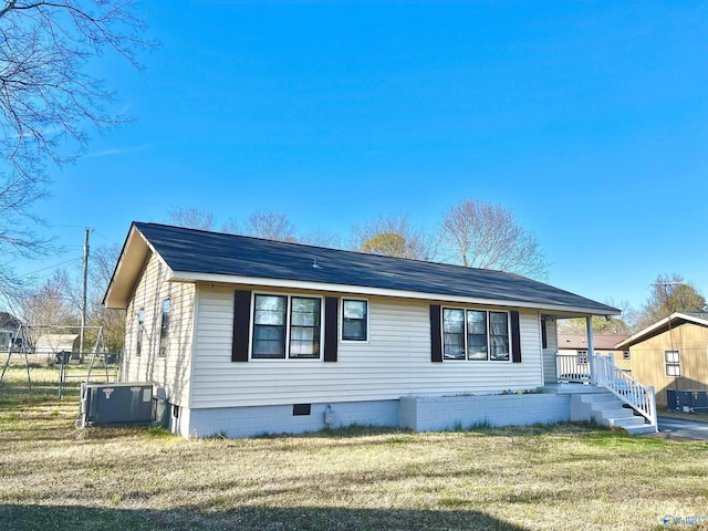 view of front facade with central AC unit, crawl space, a front yard, and fence