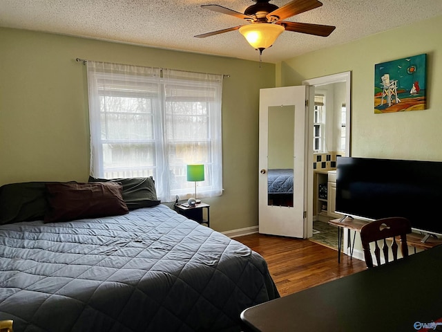 bedroom with a textured ceiling, wood finished floors, a ceiling fan, and baseboards