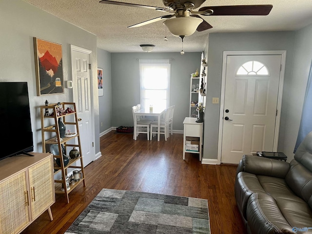 foyer entrance featuring ceiling fan, a textured ceiling, baseboards, and wood finished floors