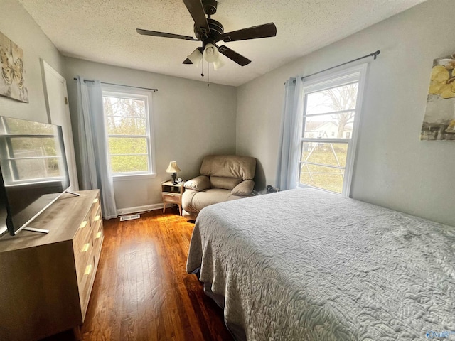 bedroom with wood-type flooring, ceiling fan, and a textured ceiling