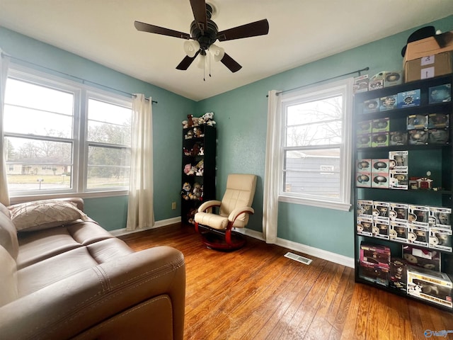 sitting room with visible vents, ceiling fan, baseboards, and hardwood / wood-style flooring