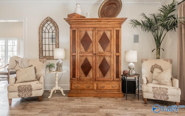 sitting room featuring ornamental molding and hardwood / wood-style flooring