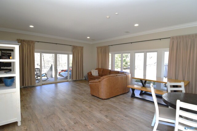 living room with light wood-type flooring and ornamental molding