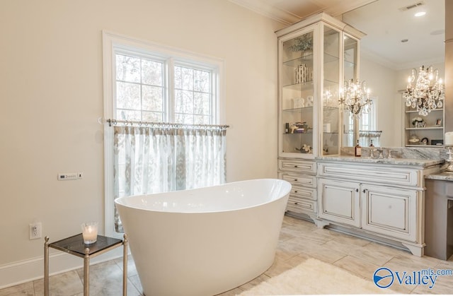 bathroom featuring tile patterned flooring, a washtub, vanity, and ornamental molding