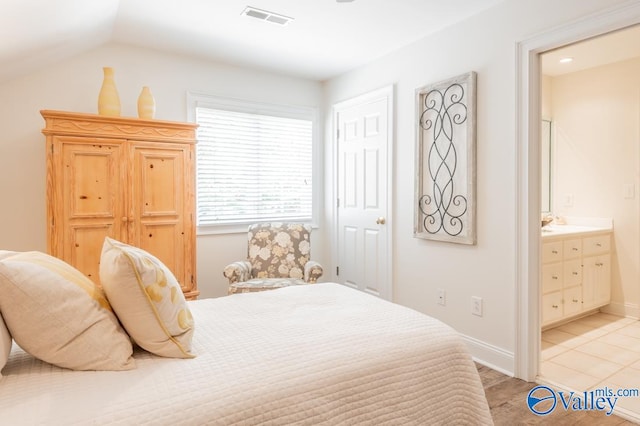 tiled bedroom with lofted ceiling and ensuite bathroom