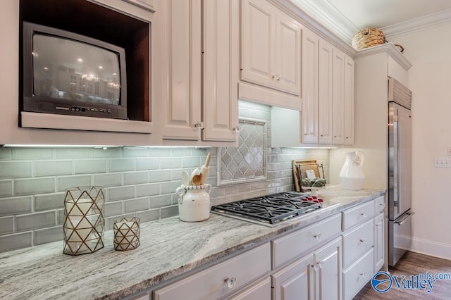 kitchen featuring appliances with stainless steel finishes, decorative backsplash, dark hardwood / wood-style floors, crown molding, and white cabinetry