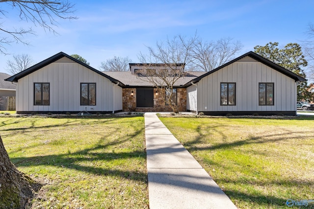 modern farmhouse featuring board and batten siding, a shingled roof, and a front lawn