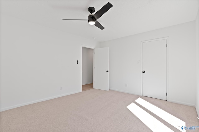 unfurnished bedroom featuring light colored carpet, baseboards, and ceiling fan