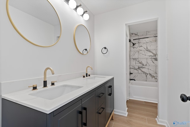 bathroom featuring bathtub / shower combination, wood tiled floor, double vanity, and a sink