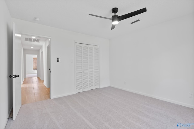 unfurnished bedroom with carpet, visible vents, and baseboards