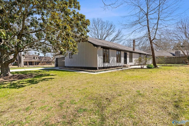 view of home's exterior featuring a yard, a garage, and fence