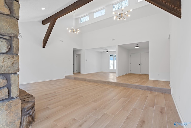 unfurnished living room featuring beamed ceiling, a notable chandelier, baseboards, and light wood-type flooring