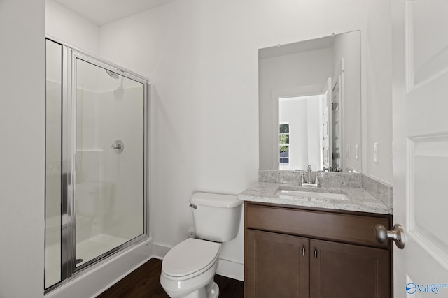 bathroom featuring vanity, a shower with shower door, toilet, and hardwood / wood-style flooring