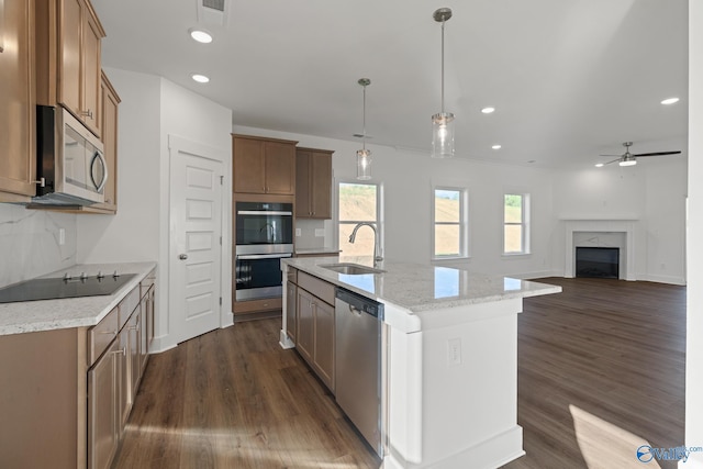 kitchen featuring pendant lighting, dark hardwood / wood-style floors, an island with sink, stainless steel appliances, and ceiling fan