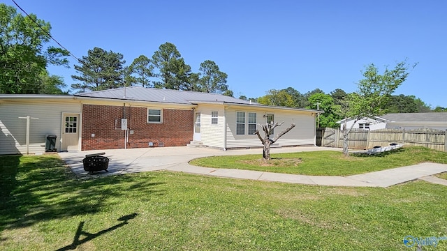 1411 W Washington St, Athens, AL 35611 - back of property featuring brick siding, fence, an outdoor fire pit, a yard, and a patio