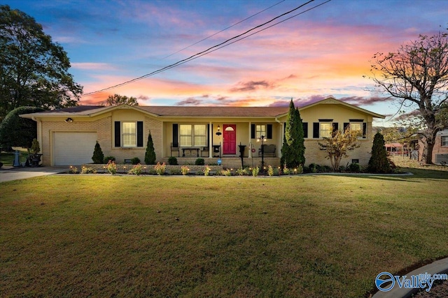 single story home featuring a yard, a garage, and a porch