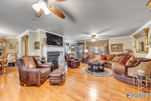 living room featuring ornamental molding, light wood-type flooring, and ceiling fan