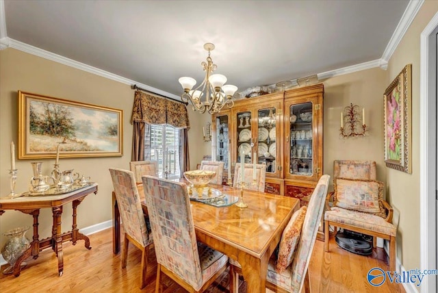 dining area with ornamental molding, a chandelier, and wood-type flooring