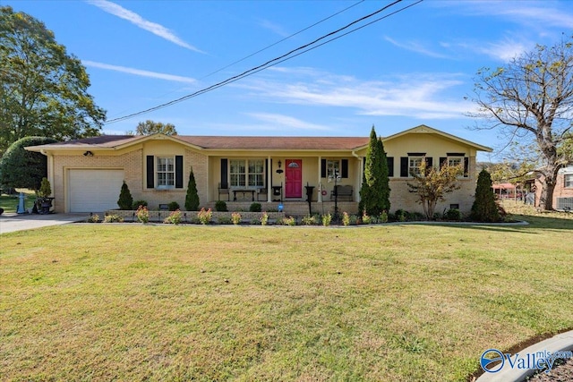 ranch-style home featuring covered porch, a front yard, and a garage