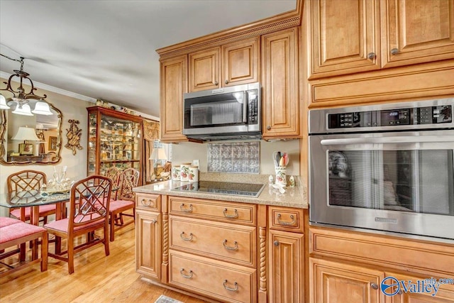 kitchen with appliances with stainless steel finishes, crown molding, decorative light fixtures, and light hardwood / wood-style floors