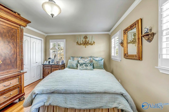 bedroom with a closet, crown molding, and light hardwood / wood-style flooring