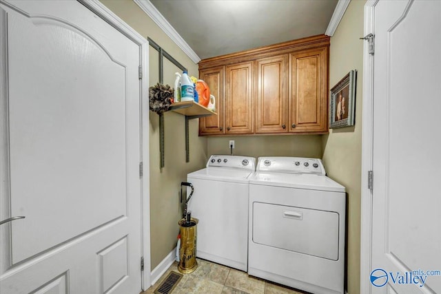 laundry room featuring cabinets, ornamental molding, and washing machine and clothes dryer