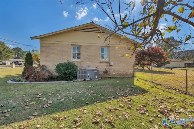 view of side of home with a yard and cooling unit