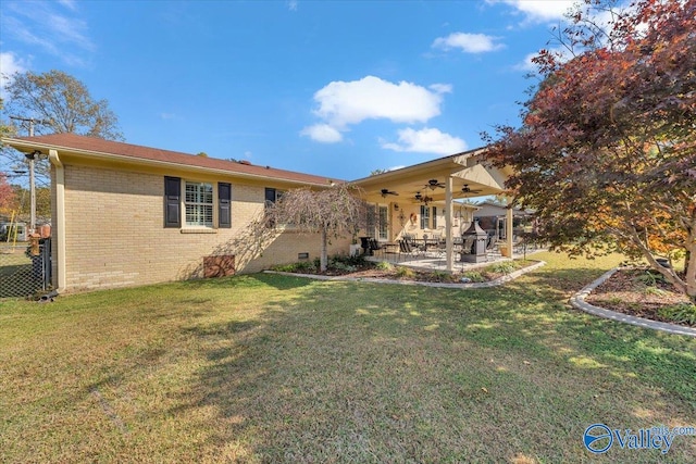 rear view of house featuring a patio, ceiling fan, and a lawn