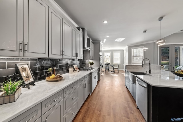 kitchen with gray cabinetry, decorative light fixtures, sink, and appliances with stainless steel finishes