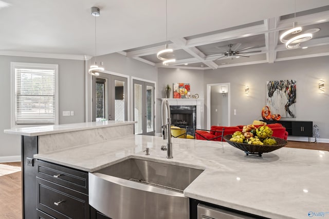 kitchen with sink, hanging light fixtures, coffered ceiling, and light wood-type flooring