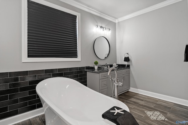 bathroom featuring a bathtub, ornamental molding, tile walls, and vanity