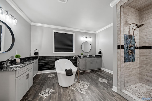 bathroom with vanity, ornamental molding, shower with separate bathtub, and tile walls