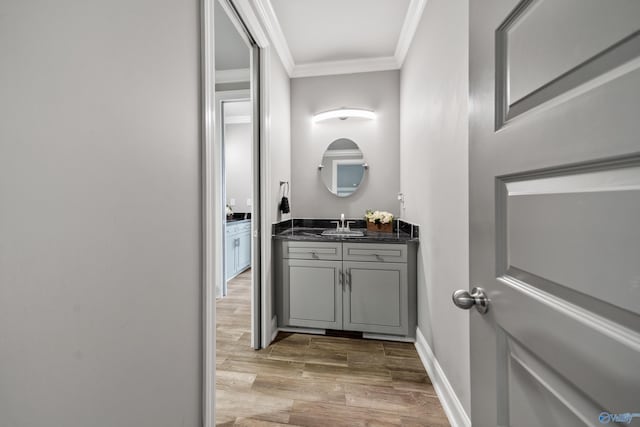 bathroom with vanity, hardwood / wood-style flooring, and crown molding