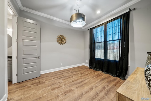 empty room with crown molding and light hardwood / wood-style floors