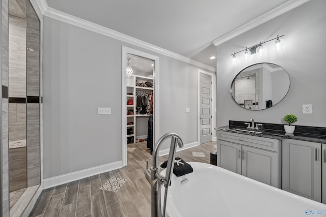 bathroom with vanity, a tub to relax in, and crown molding