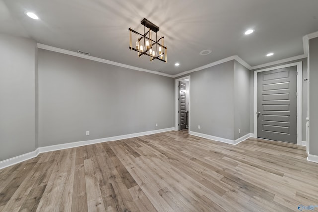 basement with light hardwood / wood-style floors, crown molding, and a chandelier