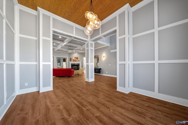 empty room featuring beam ceiling, hardwood / wood-style flooring, ceiling fan, and coffered ceiling