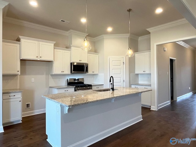 kitchen featuring sink, a kitchen island with sink, white cabinetry, stainless steel appliances, and light stone counters