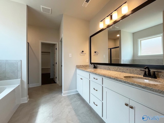 bathroom featuring plus walk in shower, vanity, and tile patterned floors